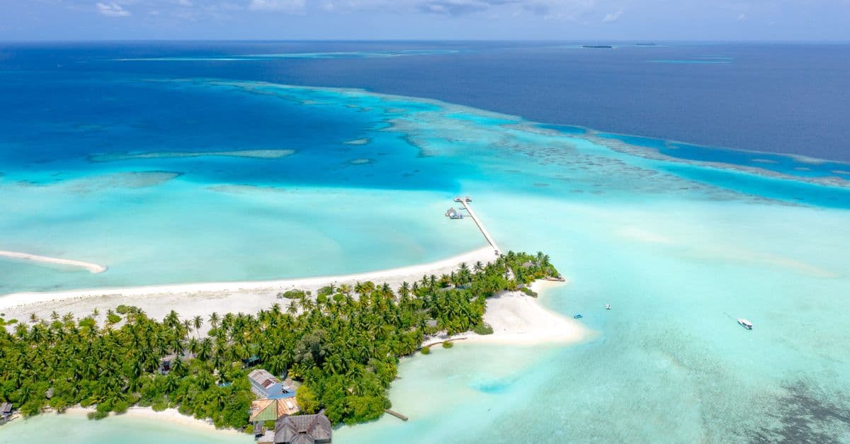 Malediven-Insel von oben mit strahlendem Sandstrand und türkisem Meer – verlässliche Hochsaison von Jänner bis März