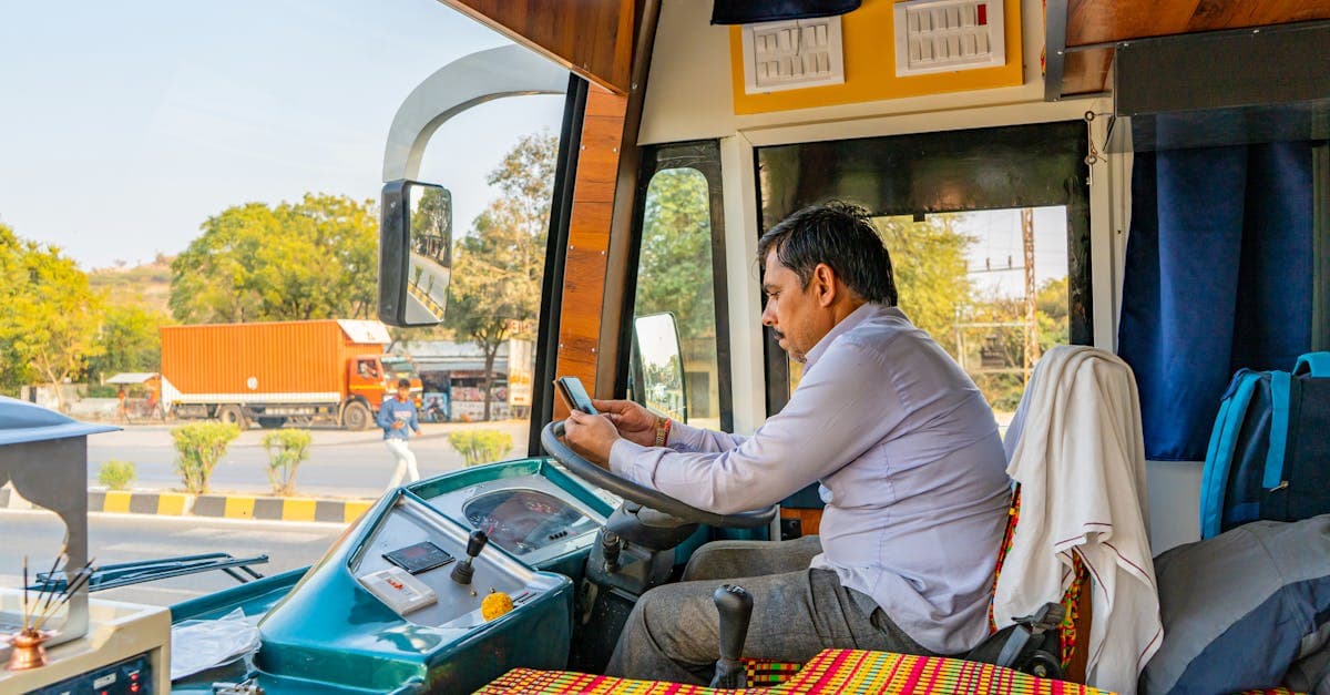 Conductor de autobús en India usando aplicaciones móviles para conectividad durante viajes