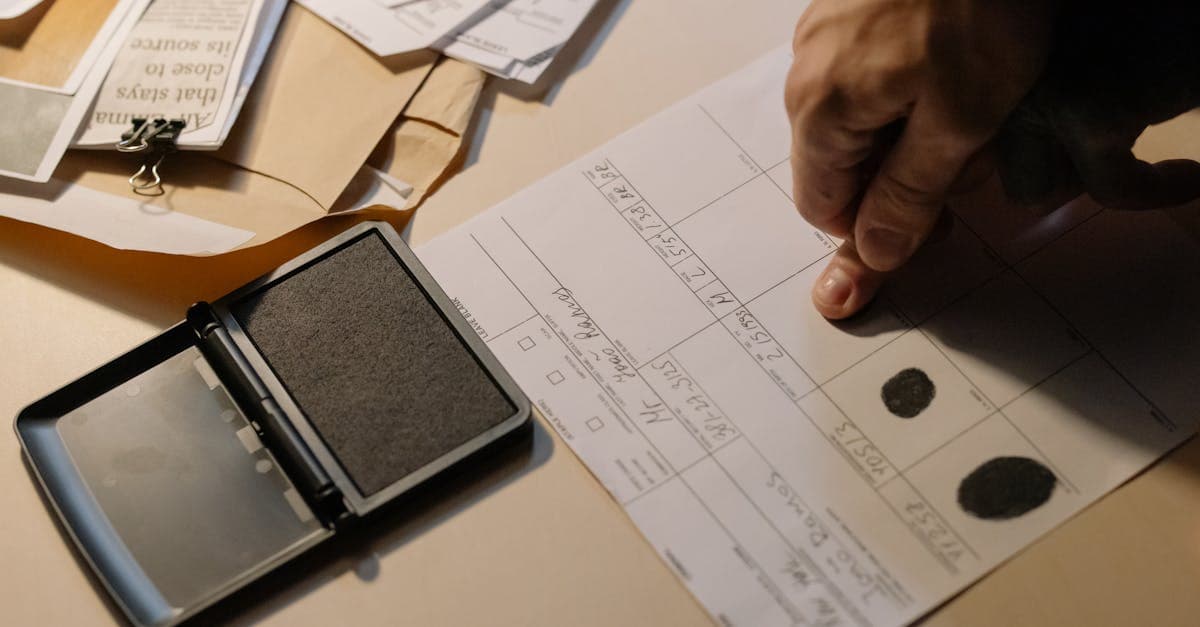 Close-up of a hand pressing fingerprints into an ink pad, representing documents needed to renew passport online