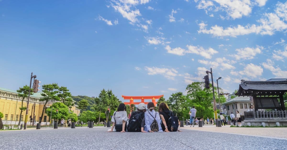ゴールデンウィーク2026に京都の鳥居を訪れる晴れやかな笑顔の若い女性グループの観光シーン