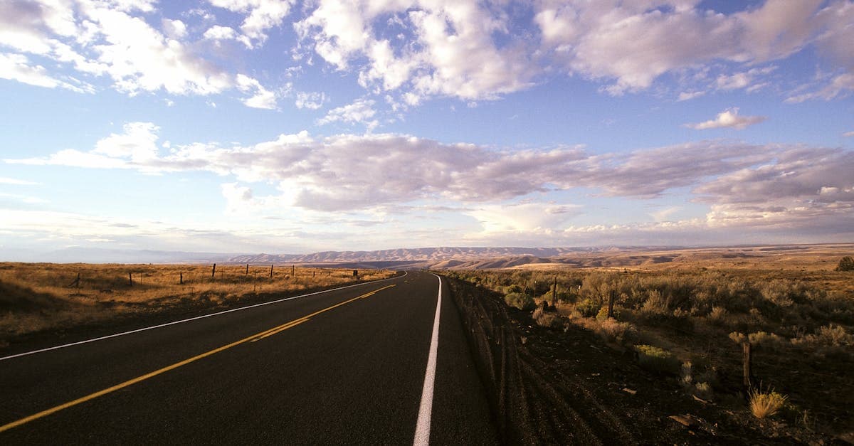 Strada infinita attraverso l'Oregon sotto un cielo drammatico, metafora della libertà di viaggiare da soli.