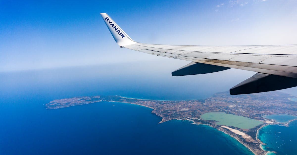Airplane wing above the Mediterranean, capturing the scenic journey on flights to Ibiza from the UK.