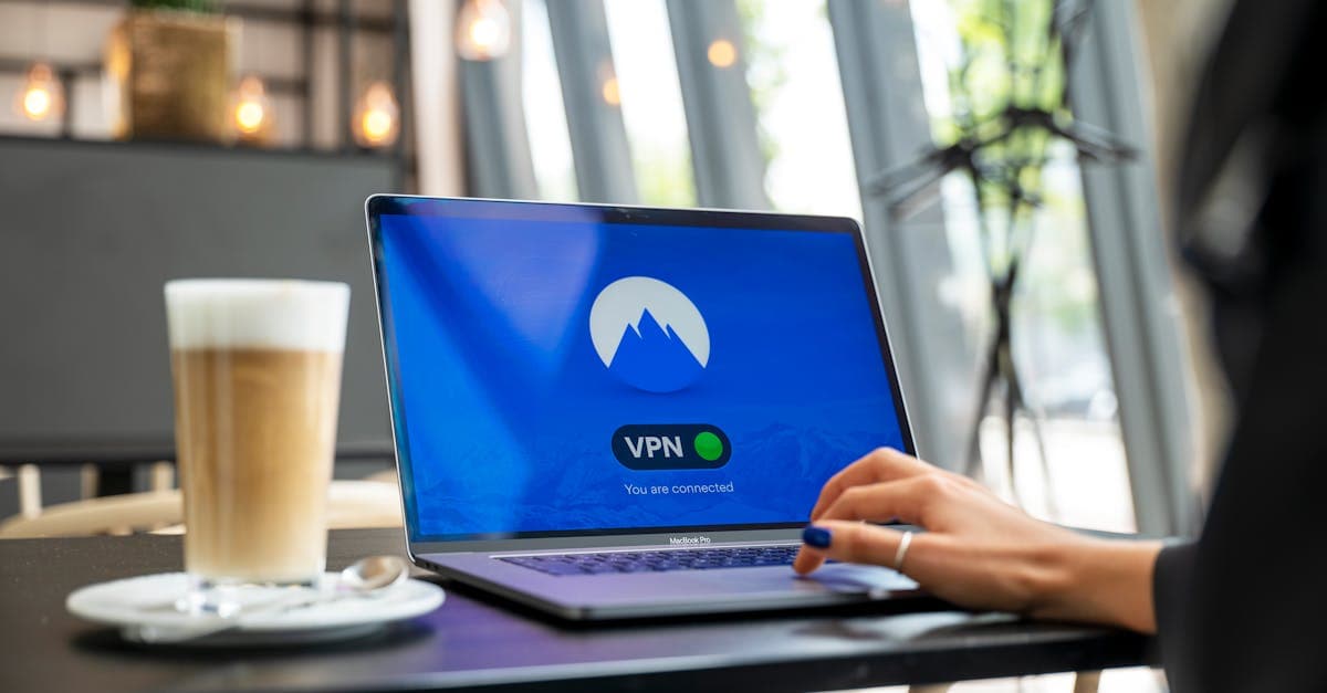 Persona trabajando con su portátil en una cafetería, protegida por su propia red wifi portatil frente al WiFi público