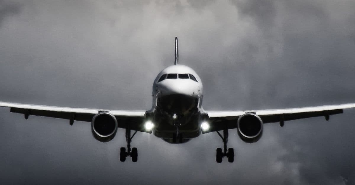 Flugzeug landet bei dramatischem Gewitterhimmel am Rhodos Flughafen in eindrucksvoller Schwarz-Weiß-Aufnahme.