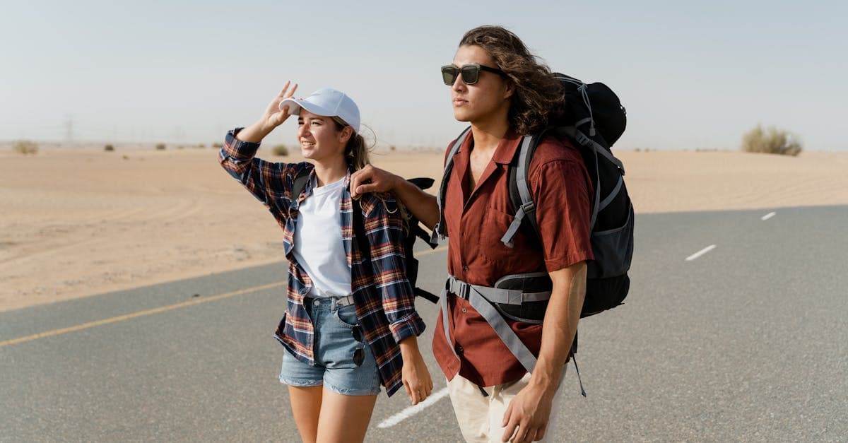 Young couple backpacking along a desert road, comparing single trip and annual multi-trip travel insurance for America