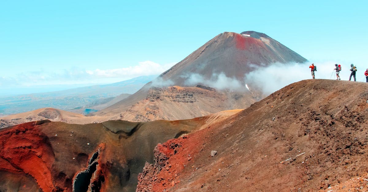 Hikers trekking through volcanic terrain near Mt. Ngauruhoe, one of the top experiences when you travel to New Zealand.