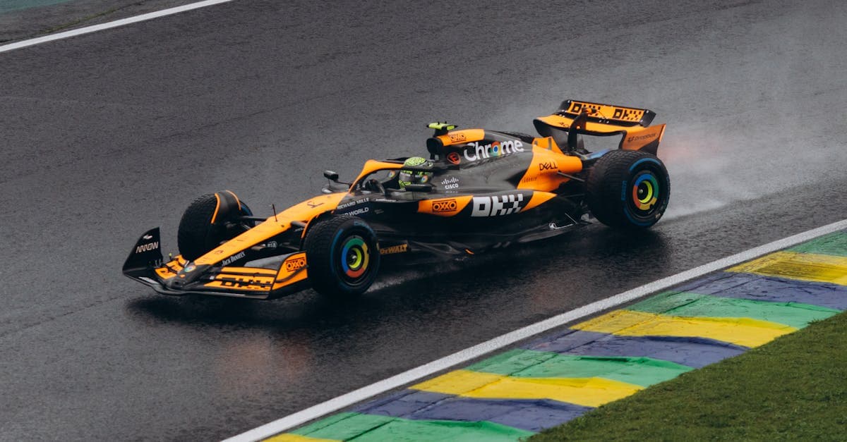 Kolorowy bolid Formula 1 pokonujący mokry tor w walce o punkty do klasyfikacji kierowców.