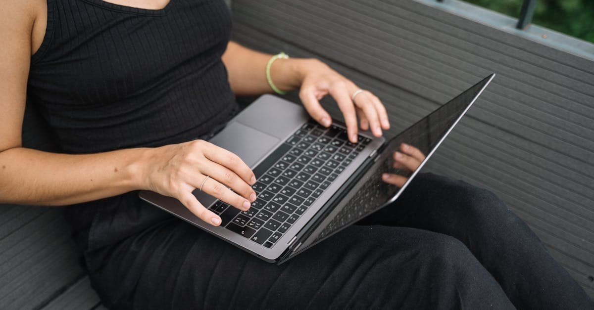 Primer plano de mujer escribiendo en portátil al aire libre, resolviendo preguntas frecuentes sobre wifi portátil.