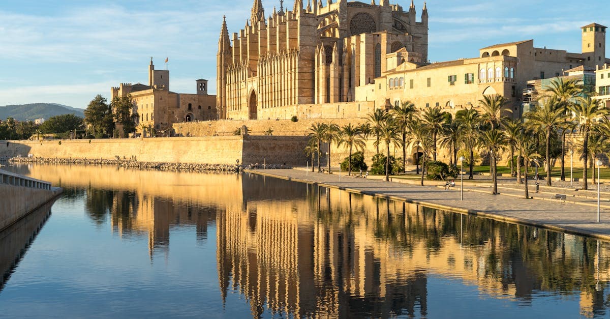 La Seu kathedraal in Palma de Mallorca spiegelt in rustig water, symbool voor het mooie weer Mallorca door het jaar heen.