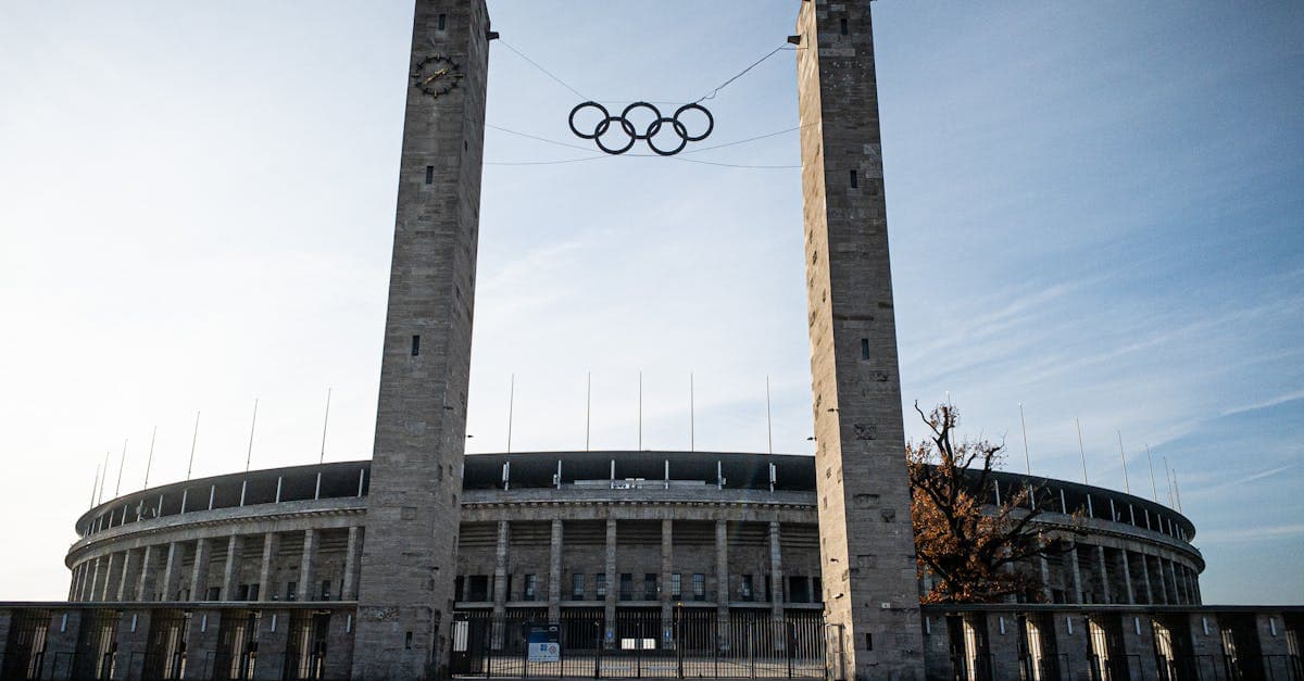 Berlin's Olympic Stadium displaying the iconic Olympic rings, representing storied venues and the tradition of global Olympic host cities.