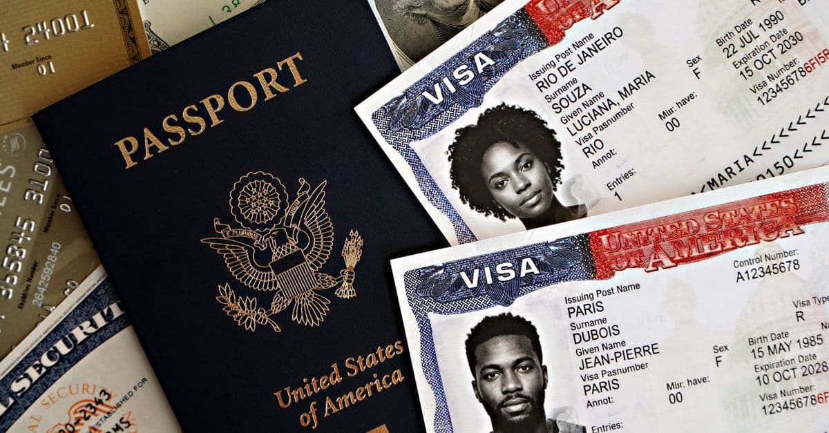 A United States passport lies beside two visa pages with applicant photos and red entry stamps.