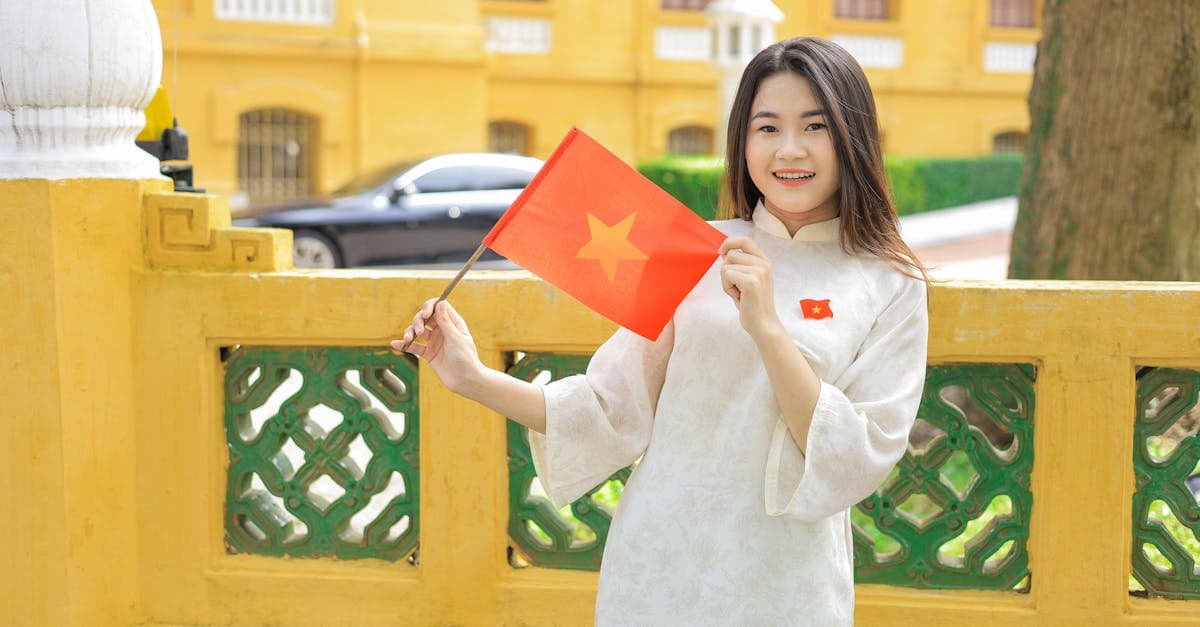 Vietnamese woman in traditional Ao Dai dress holding a flag, welcoming vietnam visa for australian holders to Vietnam.