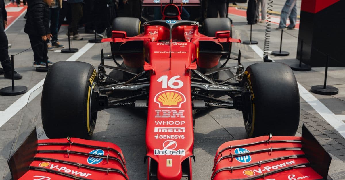 多くの観客が見守る中で展示される赤いマシンとF1 2026観戦を楽しむファンたちの熱気あふれる様子