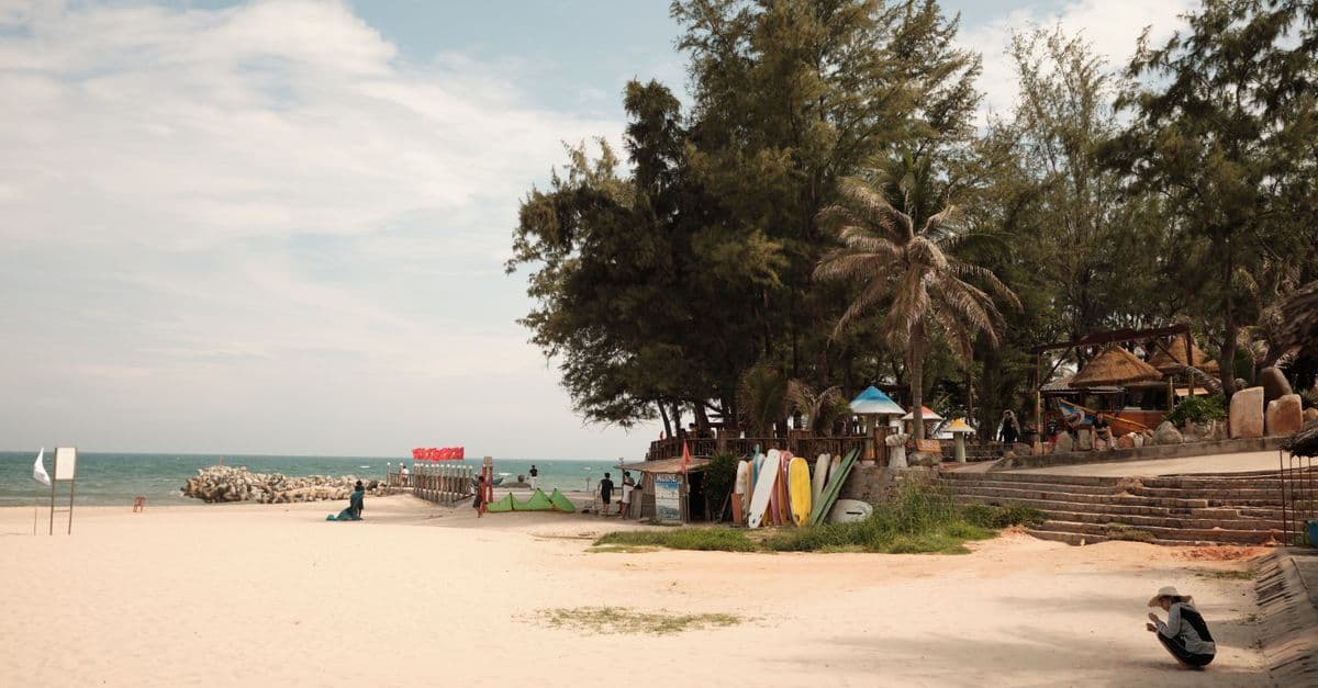 Heller Sandstrand mit ruhigem Meer, Palmen und Sonnenschein auf Phuket.