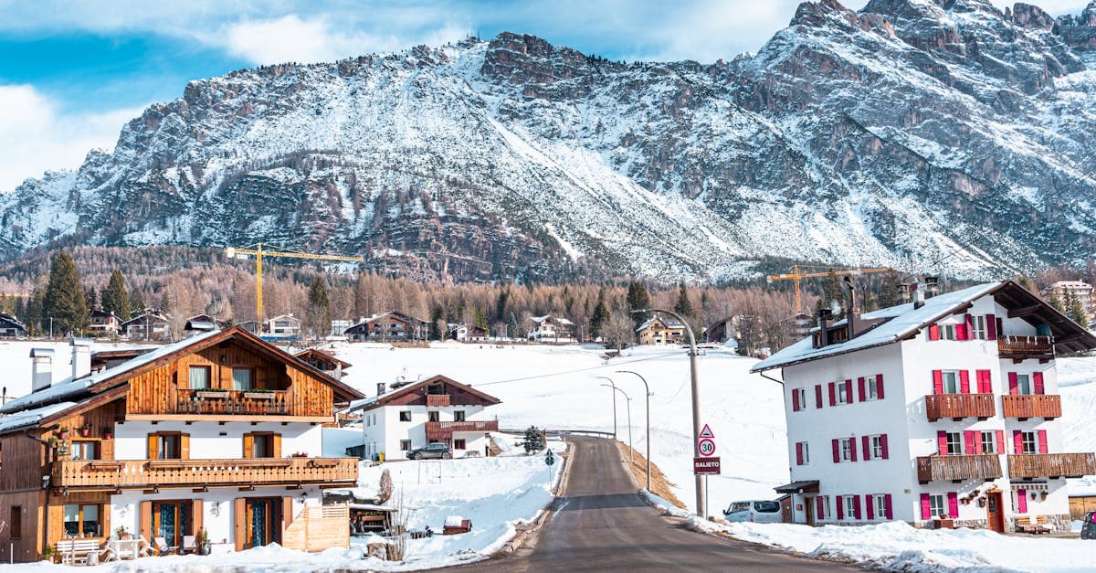 Chalets alpins traditionnels au pied des montagnes enneigées de Cortina d'Ampezzo, ville olympique des JO 2026