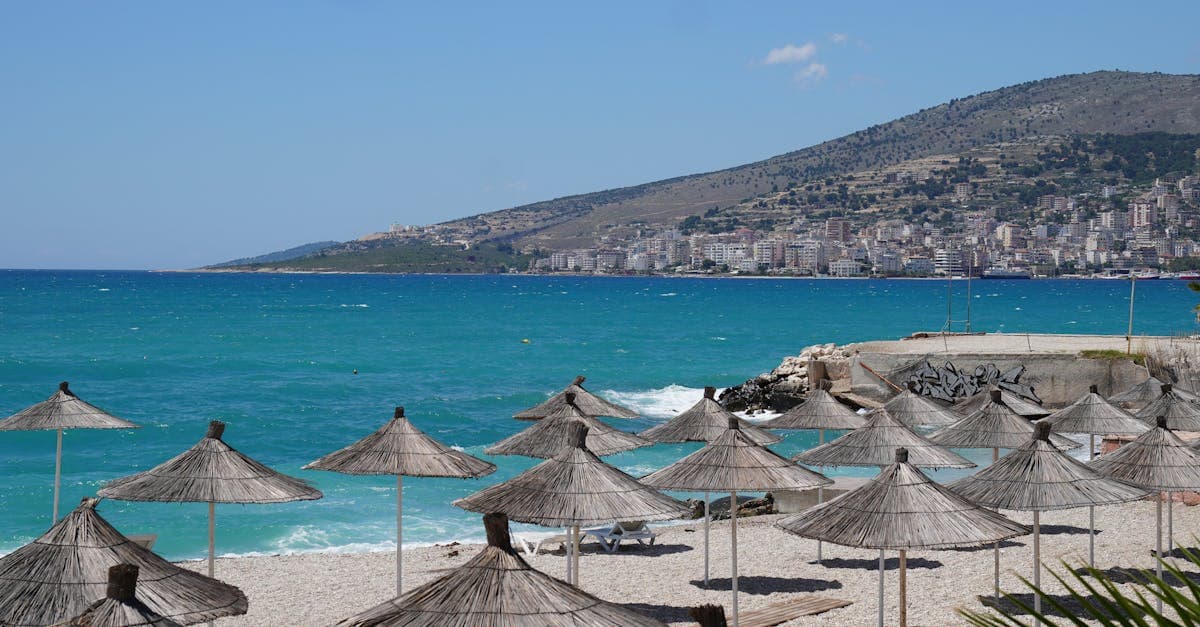 Middelhavsstrand med parasoller og byens skyline i baggrunden – tyrkiet vejr i april er varmt og solrigt