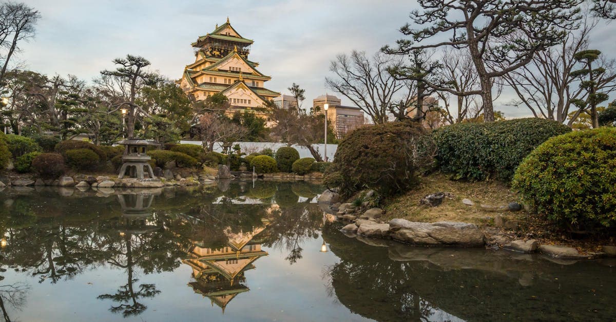 Castelo de Osaka refletido em lago de jardim ao pôr do sol, perfeito para o best time to visit japan