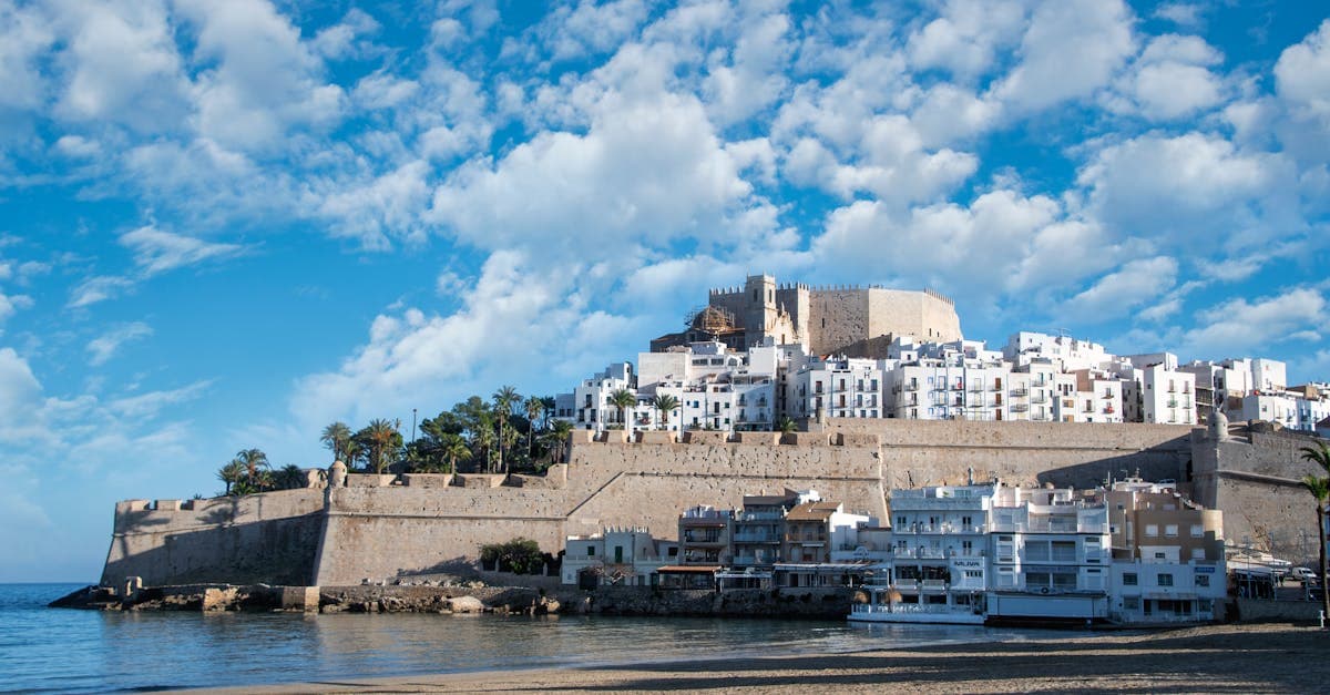 Historic castle overlooking a sun-drenched Mediterranean beach, capturing the contrast of Benidorm's old town character and heritage.