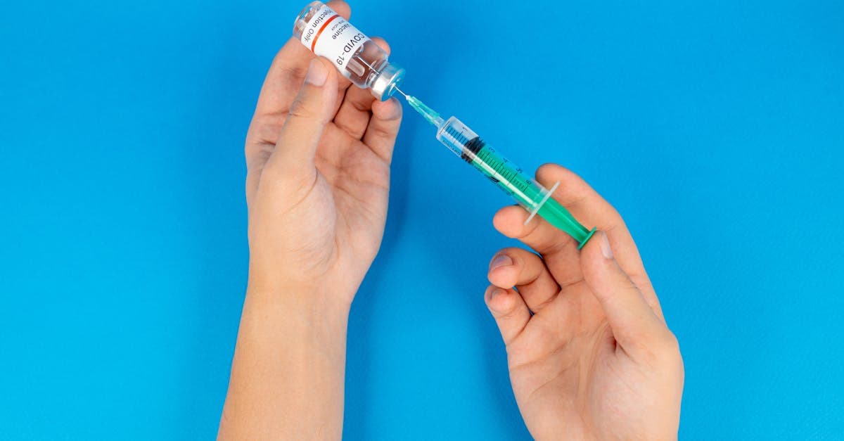 Hands holding a syringe and vaccine vial, stressing why booking travel vaccinations in advance matters