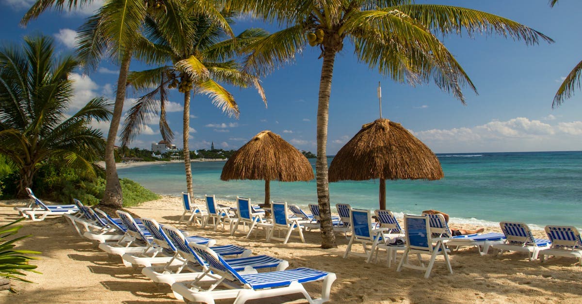 Playa idílica en Akumal, México con camastros y palmeras, perfecta para socios del Unlimited Vacation Club.
