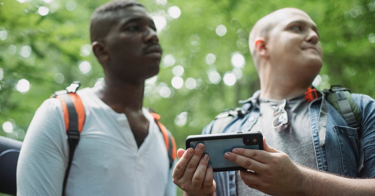 Giovani turisti multietnici controllano il percorso sullo smartphone durante un'escursione: attivare esim giappone prima della partenza