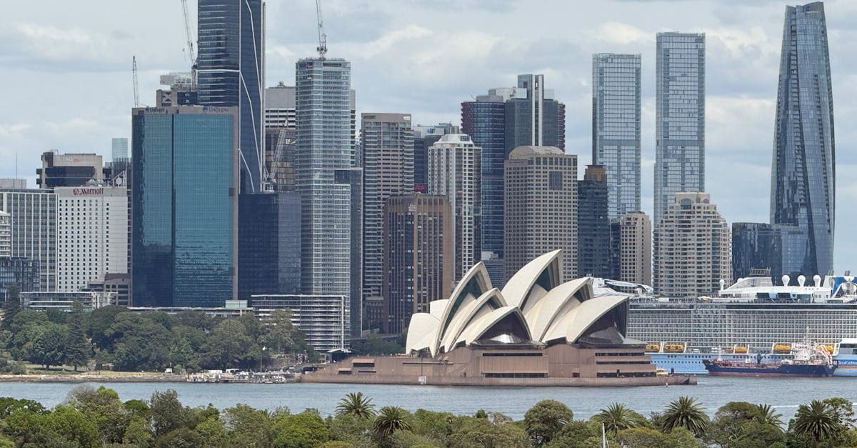 Sydney Opera House and city skyline on a sunny day, the departure point for cheap Sydney to Singapore flights.