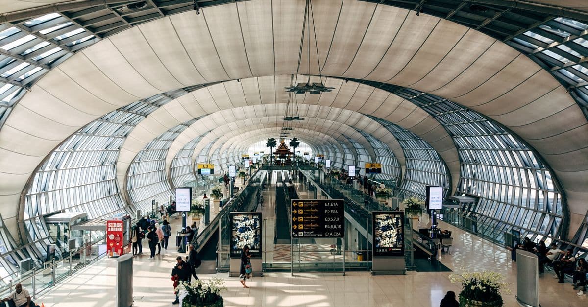 Không gian nội thất rộng lớn và tiện nghi tại sân bay Don Mueang đông đúc hành khách.