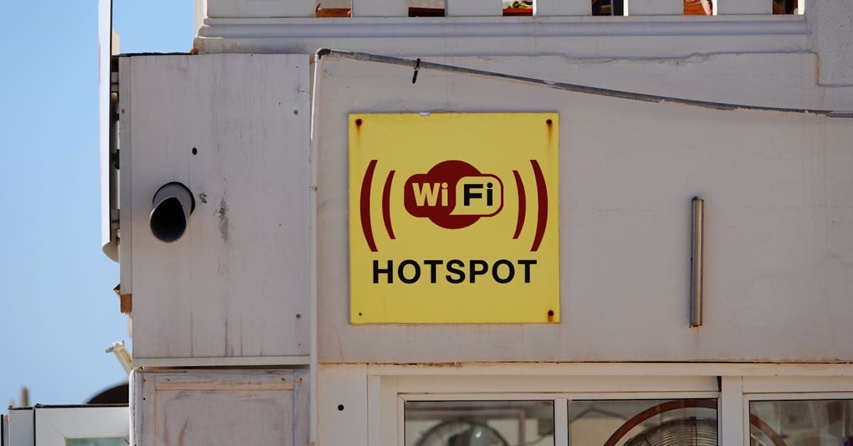 Yellow portable wifi availability sign displayed on Mediterranean building facade in Cala Rajada