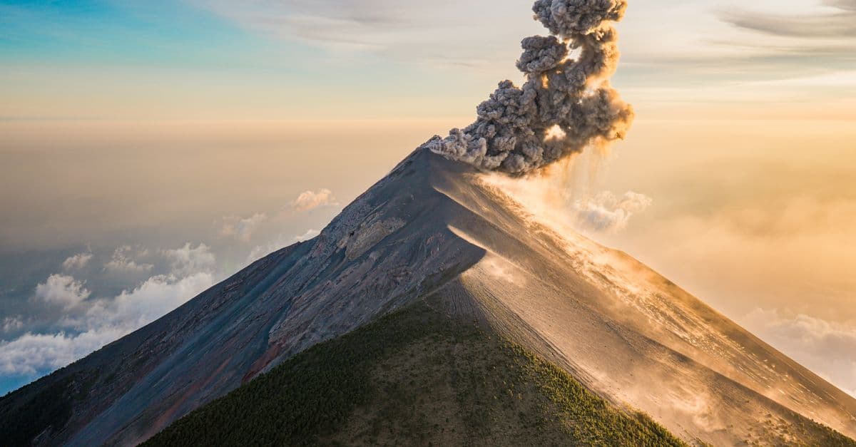 A Guatemalan volcano erupts above the clouds, sending a thick plume of ash into the sky.