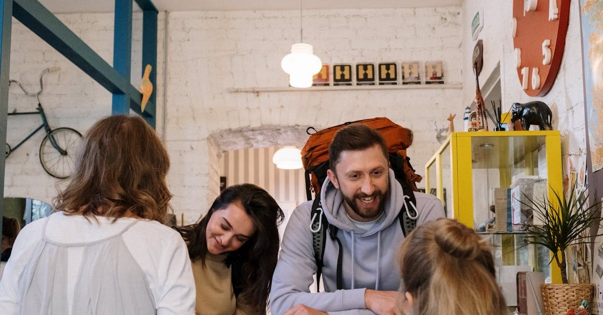 Backpackers cheerfully checking in at a hostel reception desk while planning affordable vacation destinations from Canada