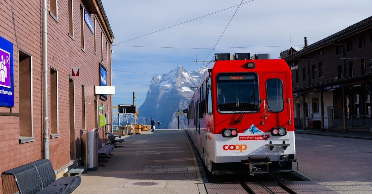 Roter Schweizer Zug an einem Bergbahnhof – ITS Coop Travel erschliesst die schönsten Alpenregionen