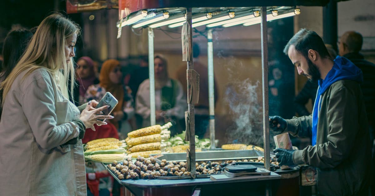 Street vendor selling grilled corn and chestnuts to customers at a bustling Vietnamese night market