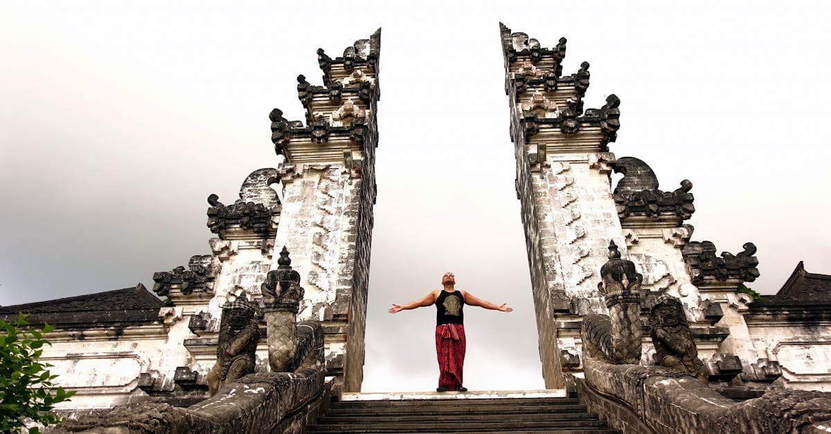 Traveller with arms outstretched at Pura Lempuyang temple during the best time to visit Bali's iconic landmarks