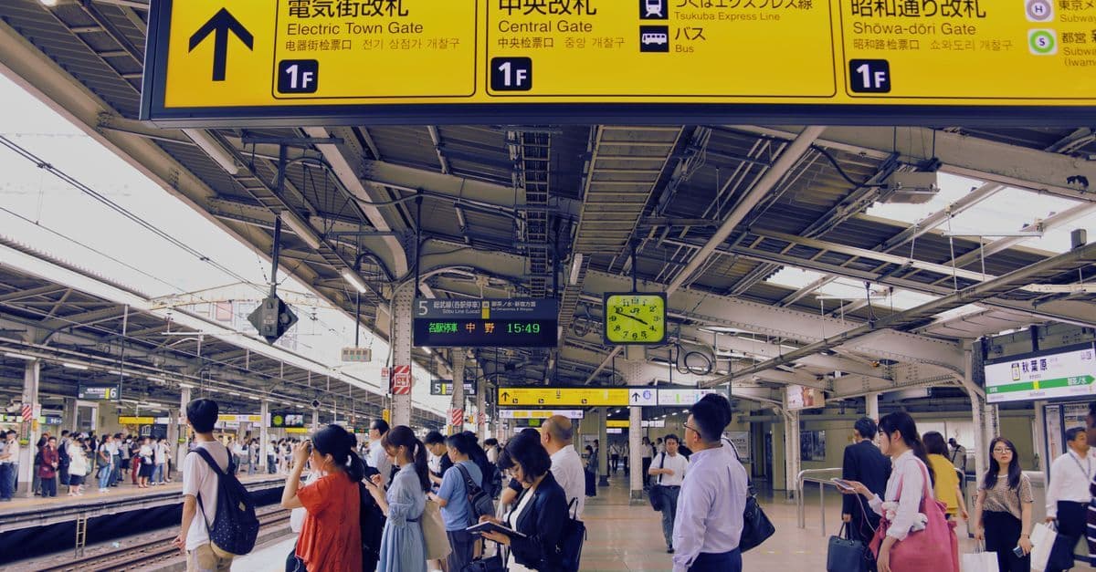 Pendler warten auf ihren Zug am geschäftigen Tokioter Bahnhof – mit eSIM Japan jederzeit vernetzt