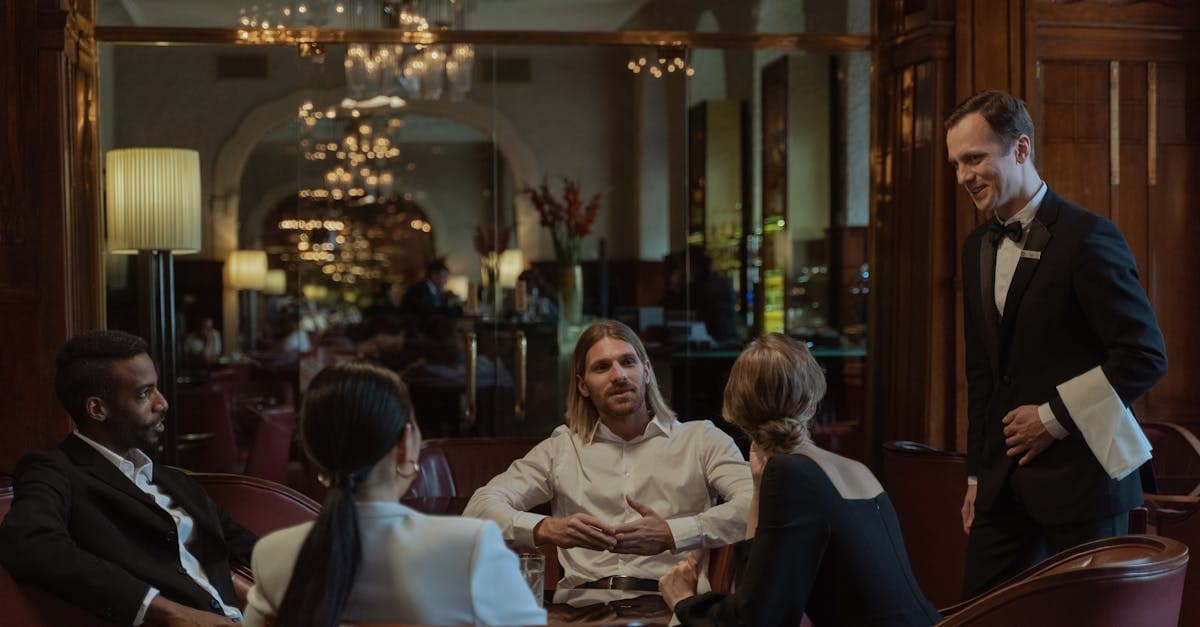 Elegante Gäste genießen ein luxuriöses Abendessen mit aufmerksamem Kellnerservice in einem gehobenen Wiener Restaurant.