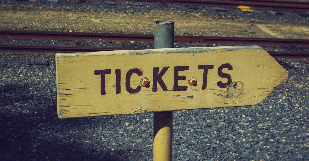 Holzschild mit Hinweis auf Ticketkauf für das Gauderfest 2026 an einem rustikalen Bahnhofsgelände.