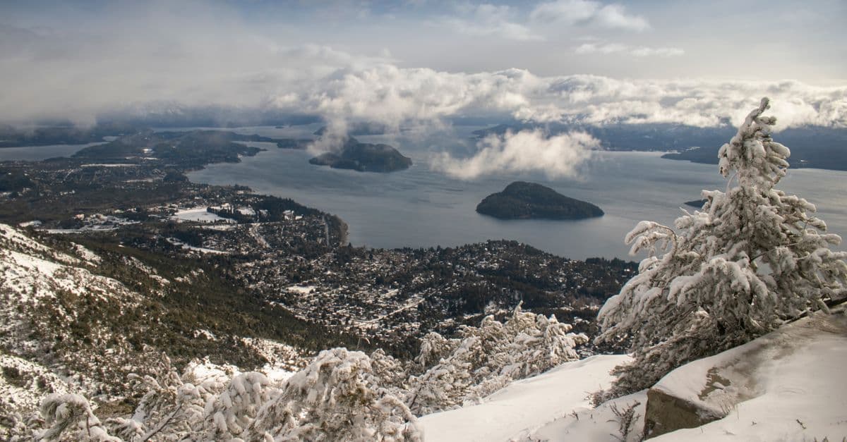 Neve em Bariloche cobrindo árvores e o lago Nahuel Huapi em bela paisagem invernal argentina