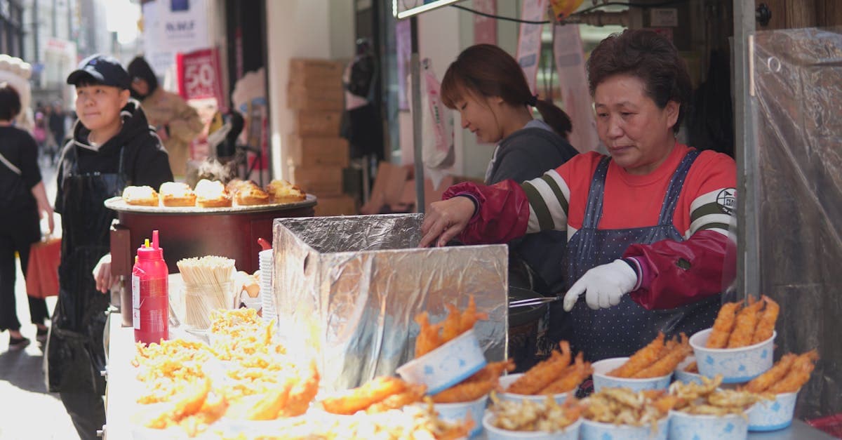 旅先の野外市場で揚げ物を販売する屋台、ソウル フードを探す旅行者に役立つ現地での通信手段と食体験