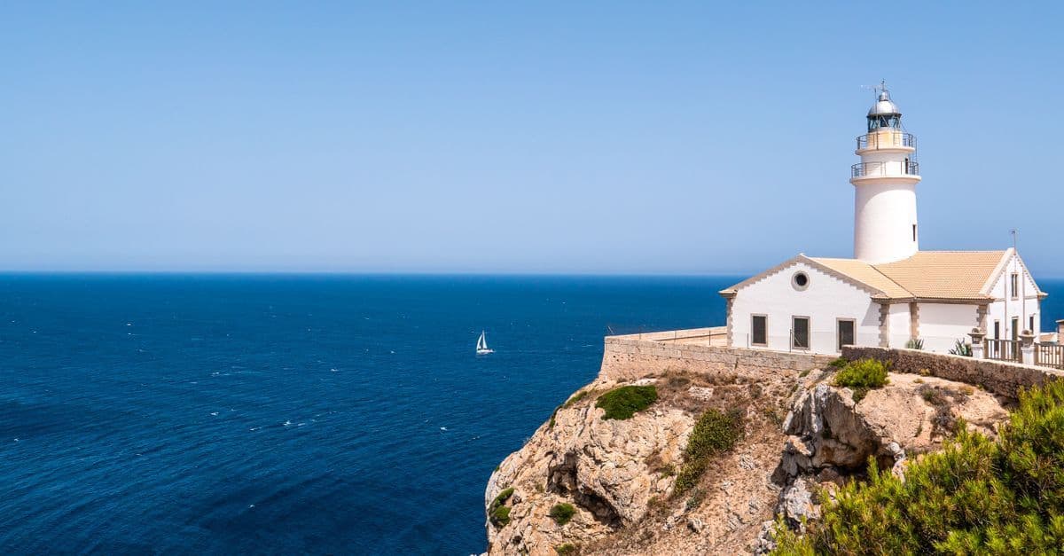 Aurinkoinen Mallorca sää näkyy kirkkaana siniselle Välimerelle avautuvalta kallioiselta rannikolta majakan luona