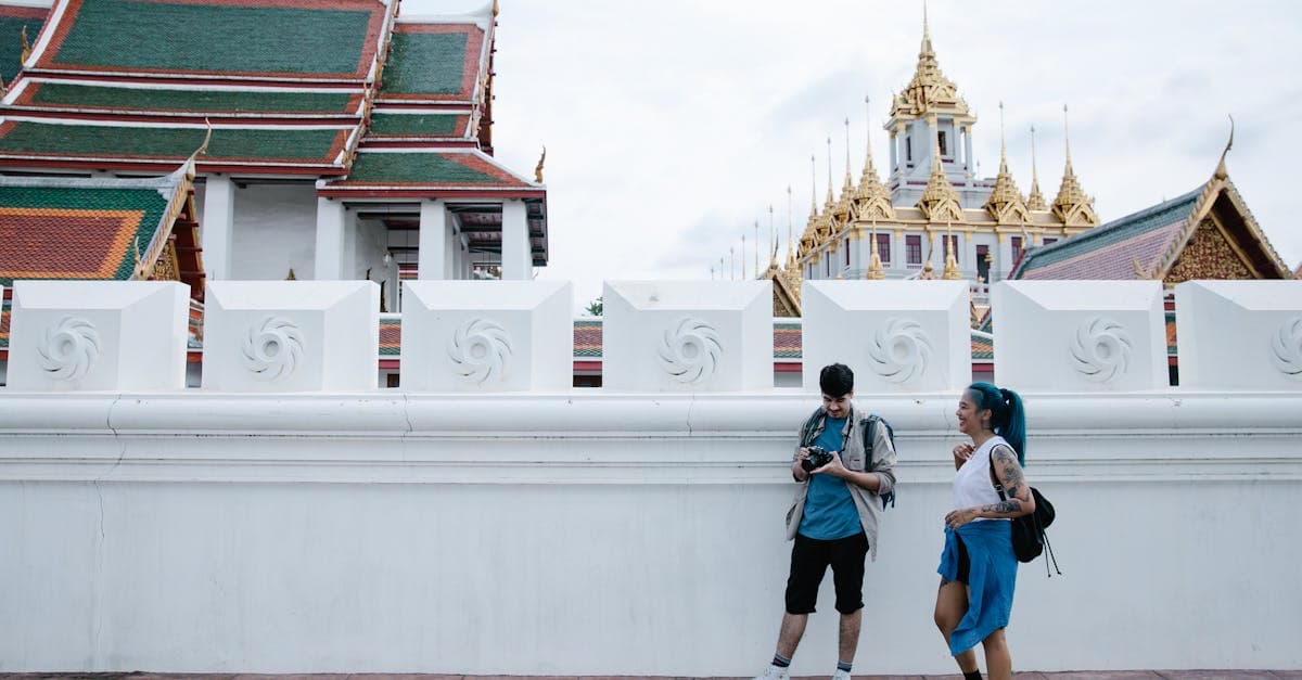 Par fotograferar ett ornamenterat thailändskt tempel med guldspira – thailand resa som gravid