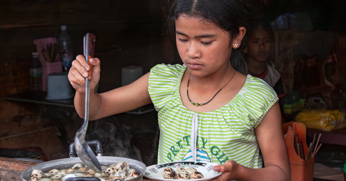Jeune femme servant des œufs de caille bouillis dans un stand de rue rustique au Vietnam