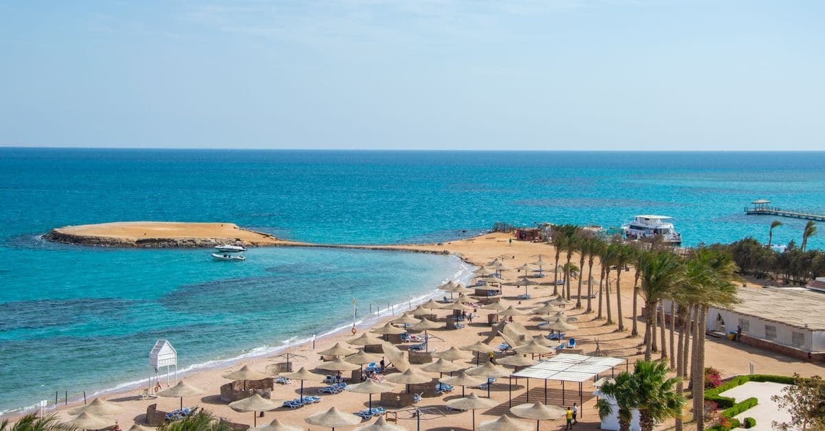 Idylliczna plaża z rzędami parasoli i lazurowym oceanem – dlaczego nie jechać do Egiptu