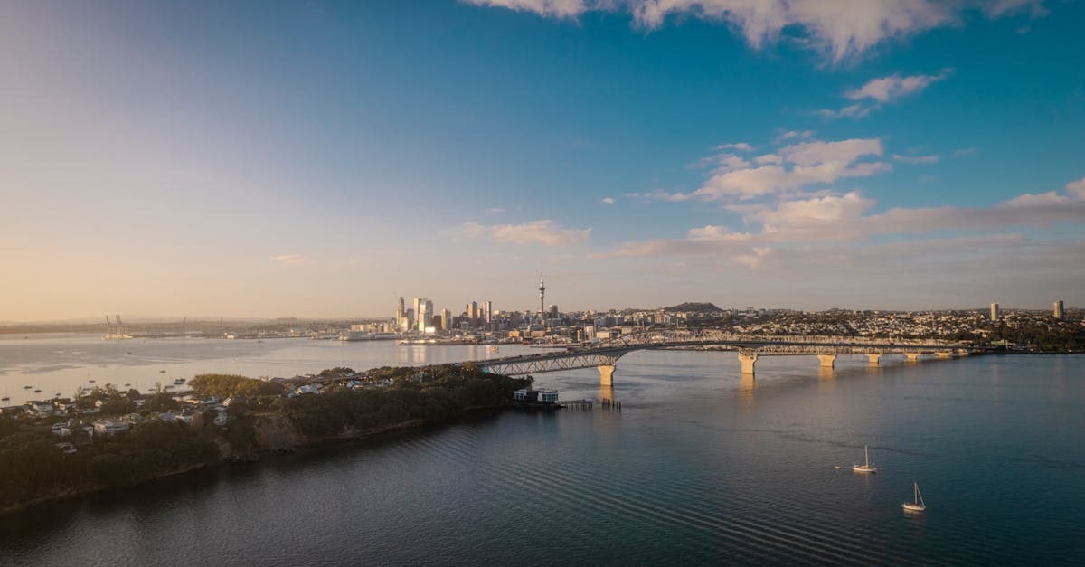 Aerial view of Auckland city skyline and Harbour Bridge at sunset, a key port of call on the cruise route.