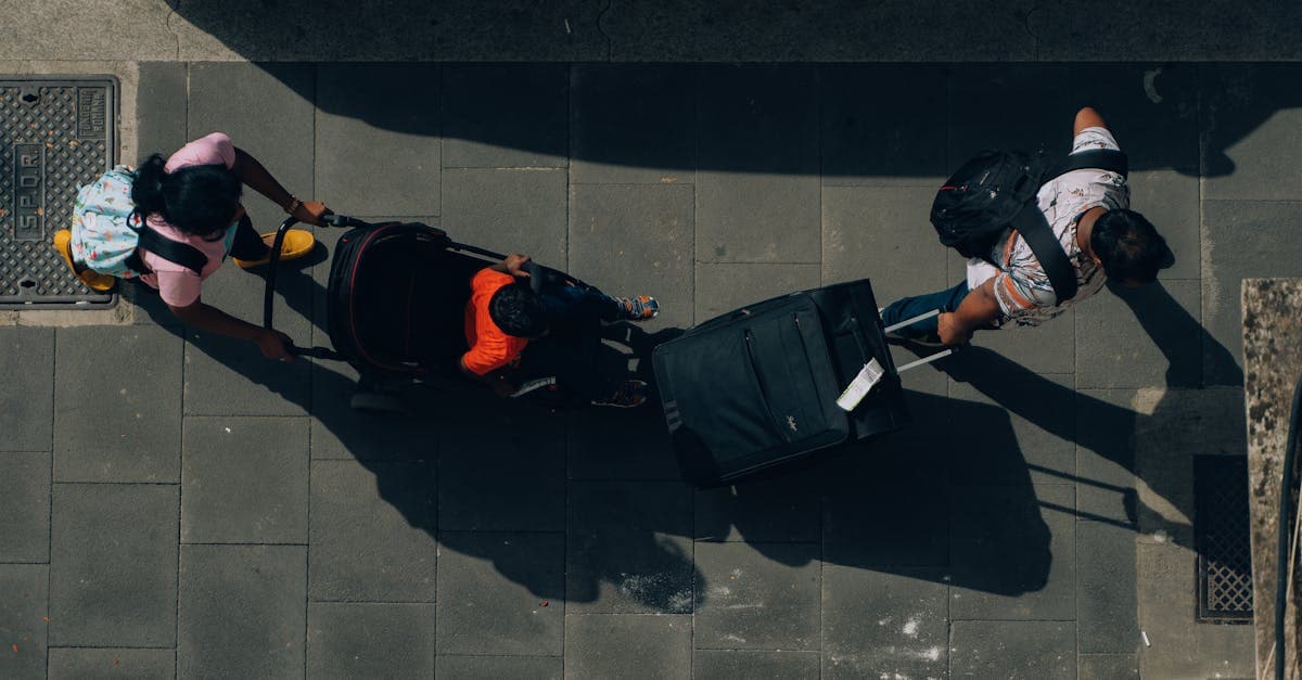 Aerial view of a family with a travel stroller and luggage navigating a cobbled Rome street