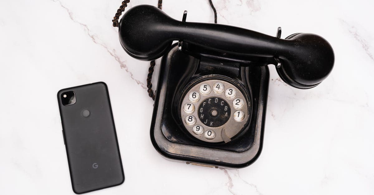 Vintage rotary phone alongside a modern smartphone on a marble surface, illustrating the evolution of mobile technology.