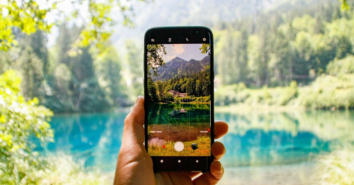 Hand hält Smartphone mit Blick auf einen Bergsee – mobile Daten für Reiseerlebnisse unterwegs nutzen