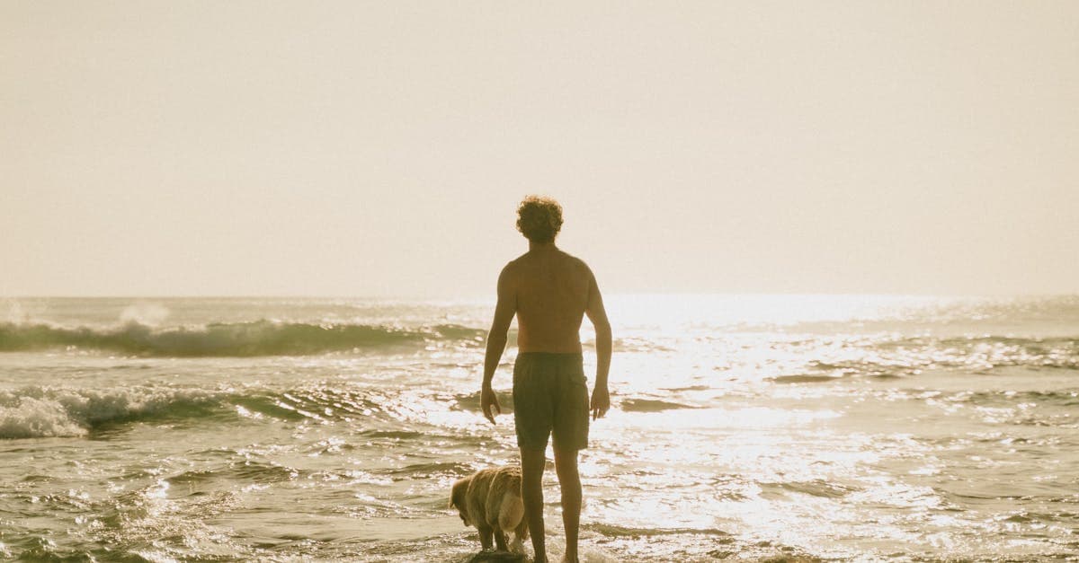 Hombre paseando por una playa de Bali al atardecer con ropa ligera para el tiempo en Bali en temporada seca