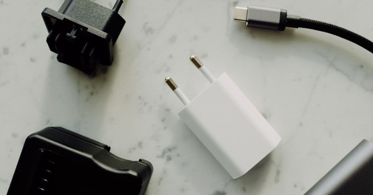 大理石の上に整然と並ぶ各国対応の変換プラグとUSB-Cケーブル、海外旅行持ち物リストに欠かせない充電グッズ