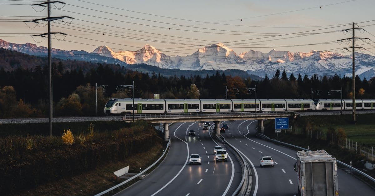 Zug überquert eine Brücke bei Bern bei Sonnenuntergang – das Schweizer Mobilnetz verbindet selbst alpine Regionen.