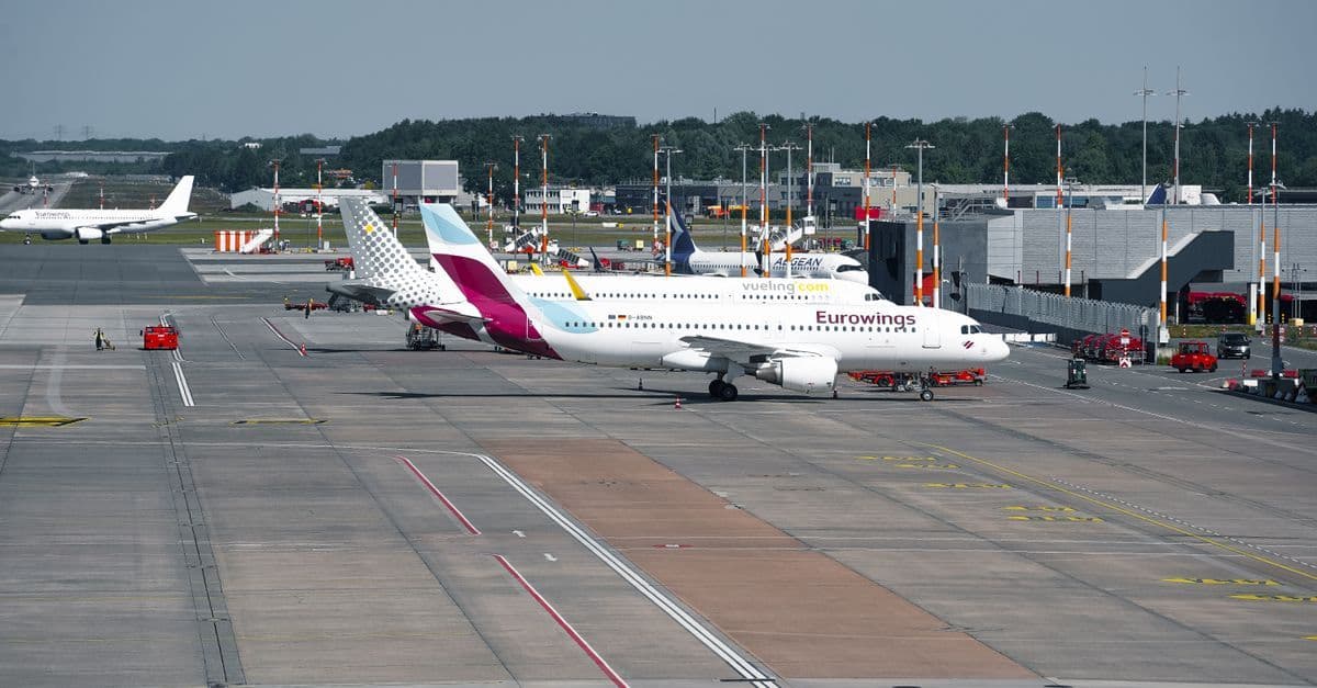 Drukke vertrekhal van Düsseldorf Airport met meerdere vliegtuigen klaar voor vertrek op de taxibaan.